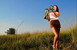 Saxophone Prints: Woman playing saxophone in nature on green background