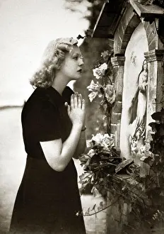 Devout Prints: Woman praying in front of Virgin Mary picture, 1920s, Germany