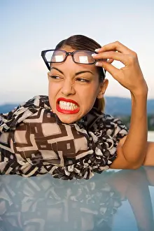 Adult Only Prints: Woman pushing eyeglasses up onto head scowling outdoors