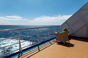 Calming Prints: Woman relaxes on deck of the Aranui 5 (Aranui Cruises) passenger cargo ship