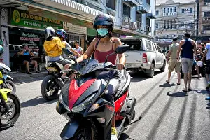 Safety Helmet Prints: Woman riding on a motorcycle. Woman wearing mask, Thailand, Southeast Asia