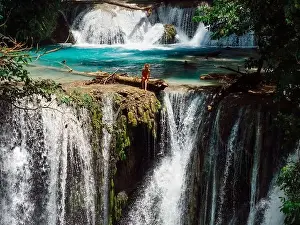 Waterfall Landscape Prints: Woman on scenic cascade waterfall with clear blue water in Central Sulawesi, drone view