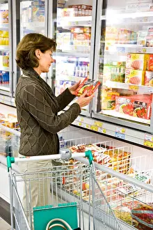 Auburn Prints: Woman shopping in the frozen food section in supermarket