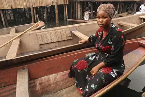 Huts Prints: A woman sits in a canoe as she sells food to makoko residents at the Makoko fishing community on the Lagos lagoon