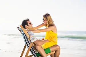 Face To Face Prints: Woman sitting on mans lap at beach