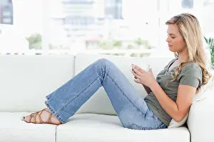 Caucasian Appearance Prints: Woman sitting sideways on the couch, cup in hands, and eyes closed