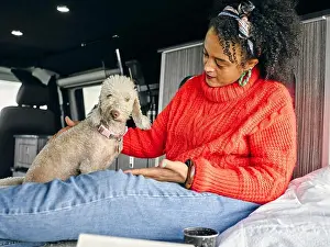 Getting Away From It All Prints: Woman sitting in back of van and playing with dog
