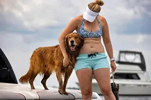 Golden Retriever Prints: Woman standing on a boat with a golden retriever dog