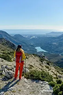 At The Edge Of Prints: A woman standing on a rocky point overlooking Mediterranean sea