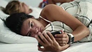 Real Life Prints: Woman staring at phone screen in the morning bed