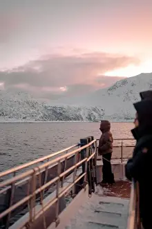 Brim Prints: Woman stood on top of boat looking at sunset over the Lyngen Alps in Norway