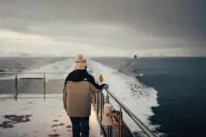 Brim Prints: Woman stood holding boat rail on Norwegian fjord in the arctic