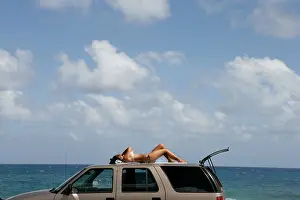 Bikini Prints: Woman sunbathing on top of a Car