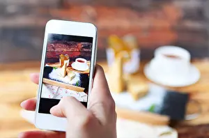 Coffee Cup Prints: Woman taking a photo of Traditional Hungarian Esterhazy cake with smartphone. Close up