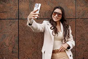 Outerwear Prints: Woman Taking Selfie in Beige Coat