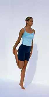 Barefoot Prints: Woman in tank top and shorts standing on one leg with her hand around the ankle of the raised leg