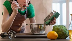 Smelling Prints: Woman tasting food in kitchen at home