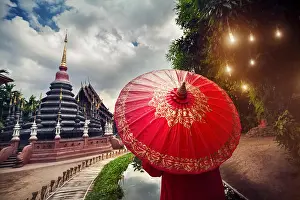 Chedi Prints: Woman tourist with red traditional Thai umbrella in Black temple Wat Phan Tao in Chiang Mai
