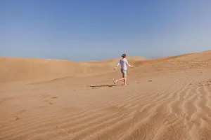 Oman Prints: woman tourist running in sand dunes