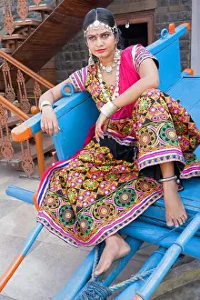 Rajasthani Prints: Woman in traditional Rajasthani attire with mirror work seated on a bullock cart