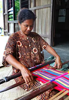 Weaving Prints: Woman traditionally weaving tais on backstrap loom in Timor Leste (East Timor)