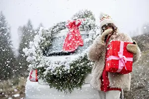 Presents Prints: Woman travels by car with presents and Christmas wreath on the mountain road