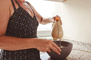 Housewife Prints: Woman using electric mixer for preparing cheesecake ingredients. Family gastronomy