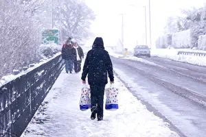 Snowing Prints: Woman walking away, carrying a shopping bag in each hand