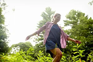 Simple Living Prints: A woman walking through the undergrowth in woodland