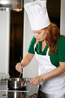 Bending Prints: Woman wearing apron and chef's hat cooking in kitchen