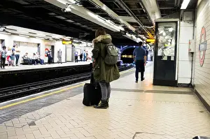 Public Transportation Prints: Woman wearing parka on District / Circle Line underground platform at Victoria Station in London