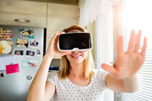 Reality Prints: Woman wearing virtual reality goggles standing in a kitchen