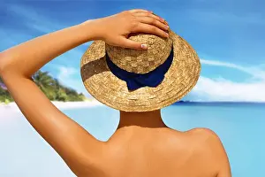 Lotion Prints: woman in white bikini resting on the beach in straw hat