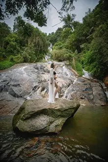 Robe Prints: A woman in a white robe stands on a rock by a lush tropical waterfall