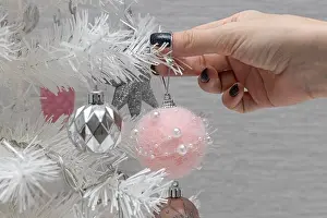 Spruce Prints: a woman's hand decorates a christmas tree with a toy. High quality photo