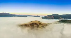 Wonderful autumn landscape in the mountains at dawn. Drone view of the autumn forest and low clouds