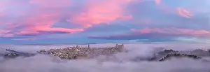 From above wonderful landscape of medieval castle built over city in misty colorful sunrise