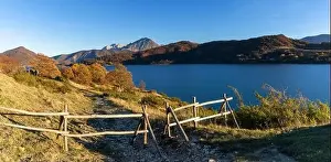 A wooden fence and hiking trail on the banks of Campotosto Lake in the mountains of Abruzzo in Italy