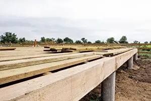 Screw Prints: Wooden frame house foundation on screw piles, construction site