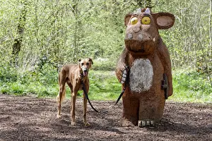 Arboretum Prints: Wooden statue of The Gruffalo holding a dogs lead as though taking it for a walk