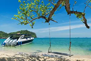 Motorboat Prints: Wooden swing chair hanging on tree near beach at island in Phuket