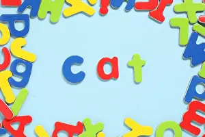Magnetic Prints: Word Cat made of magnetic letters on light blue background, flat lay. Learning alphabet