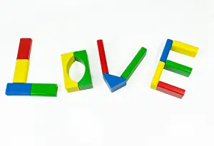 Arranged Prints: The word 'love' formed by arranging into letters colored wooden pieces