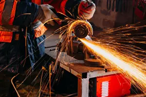 Engineering Equipment Prints: Worker cutting metal with grinder in his workshop. Sparks while grinding iron