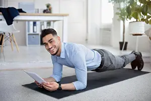 Elbow Prints: Workplace fitness. Young Arab businessman exercising on yoga mat