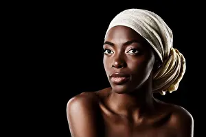 Femininity Prints: Wrapped in style. Studio shot of a beautiful woman wearing a headscarf against a black background