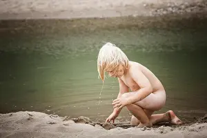 Playtime Prints: A four year old boy wearing no clothes plays on a sandy beach of Lake Michigan