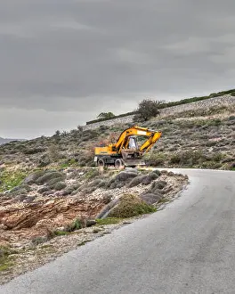 Construct Prints: Yellow Bulldozer Coming Down An Empty Seaside Road. Stock Image