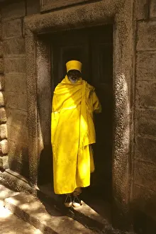Ethiopian Prints: Yellow clad Ethiopian priest or monk as gurdain to a family tomb in Addis Ababa