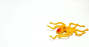 Plush Prints: A Yellow Octopus Shaped Children's Toy With Isolated White Background And With Composition Leaving Space On The